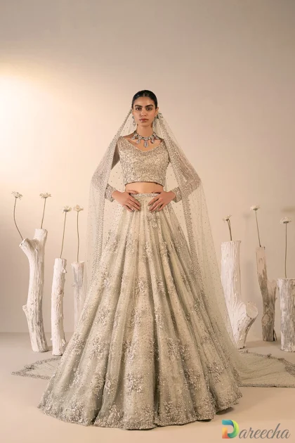 Front view of model wearing mint green bridal lehenga choli with silver zardozi embroidery and trailing embellished veil