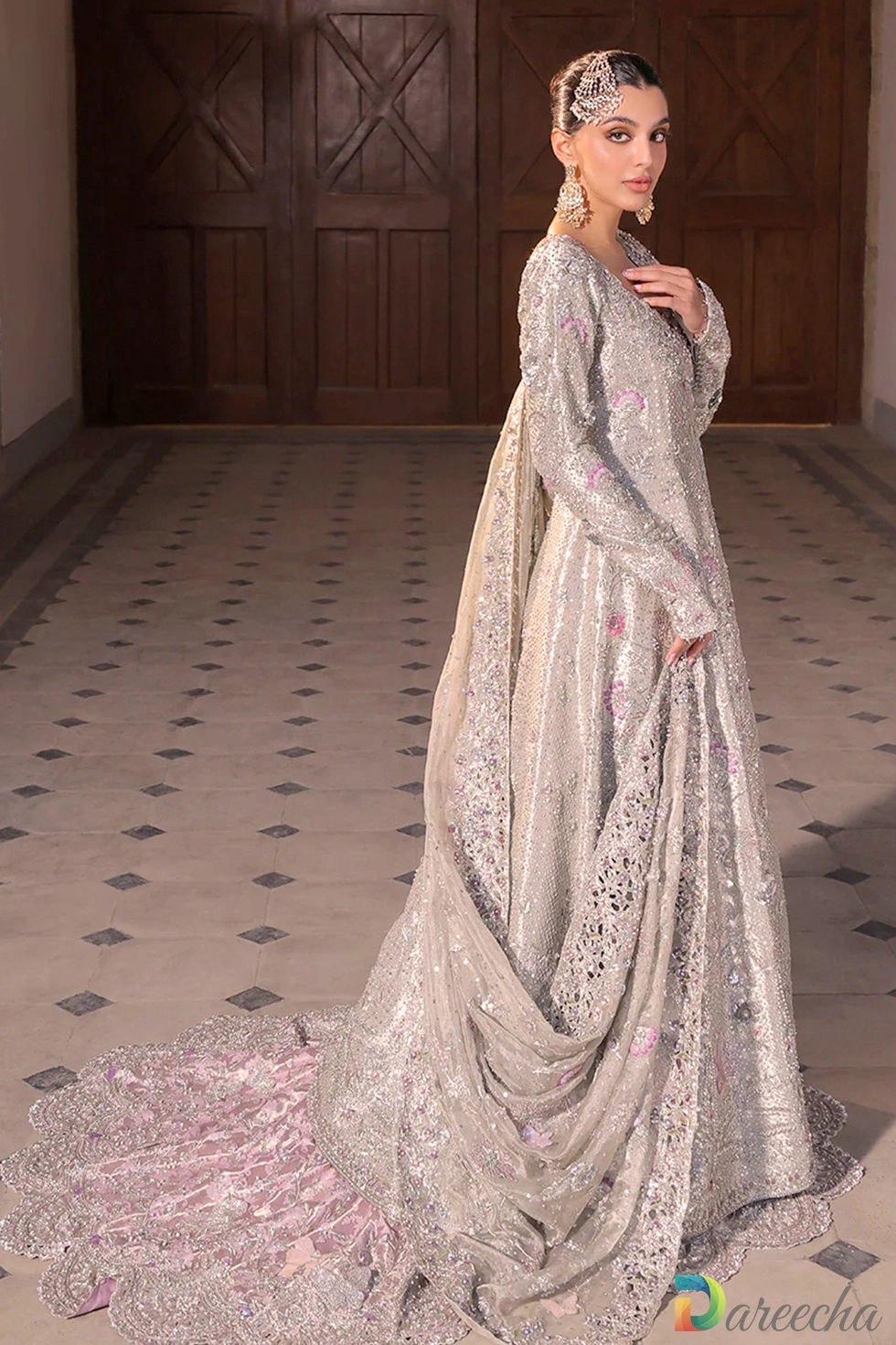 Side profile of bride wearing platinum bridal peshwas lehenga with heavy zardoze and resham floral embroidery