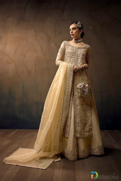 Front view of model wearing a gold organza bridal sharara with heavy zardozi embroidery and frost blue details