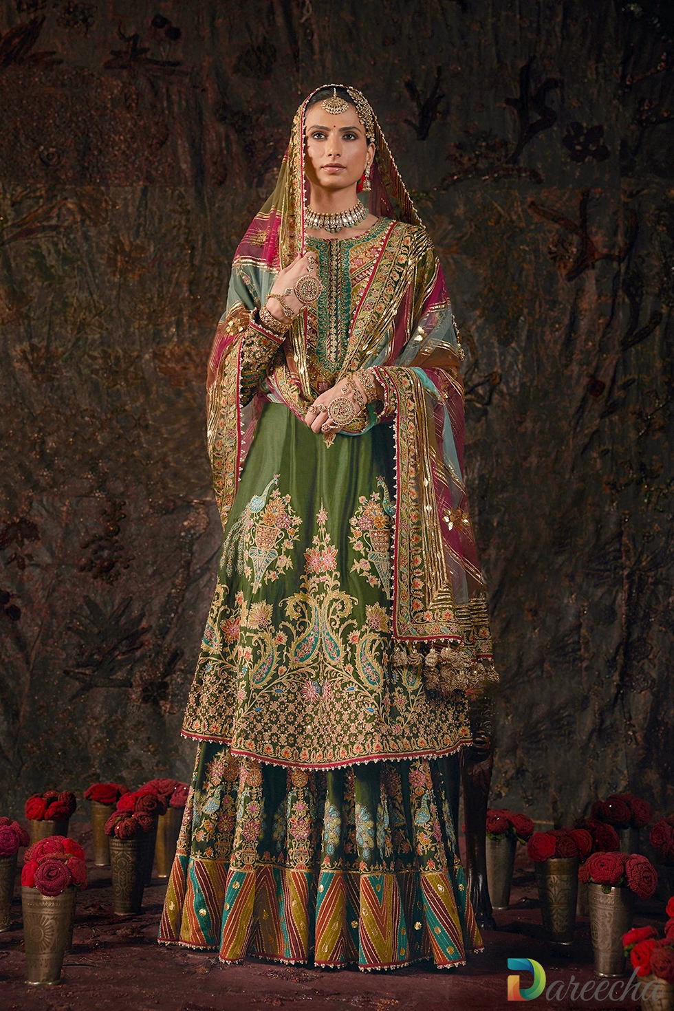 Standing full length view showcasing forest green silk sharara with multi hued tulle dupatta and detailed dushala