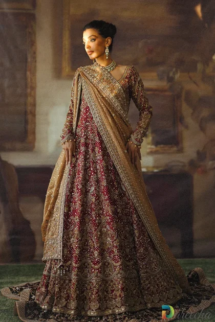 Full length standing profile of model wearing crimson bridal peshwas lehenga showcasing scalloped sleeves and flared brocade skirt
