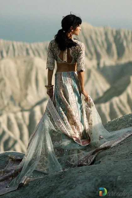 Back profile highlighting cutwork choli design with gold three dimensional tassels on pastel bridal lehenga