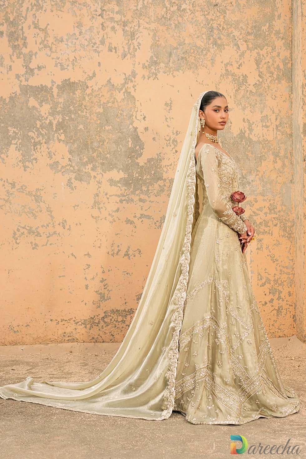 Side view profile of front open gown with lehenga showing trailing tissue silk dupatta and embroidered front slit gown