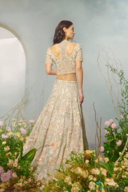 Back view showing cutout razor back jacket structure of white lehenga jacket set with crystal fringe