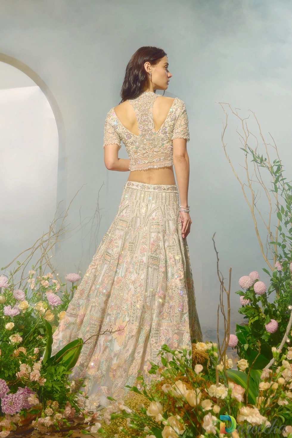 Back view showing cutout razor back jacket structure of white lehenga jacket set with crystal fringe