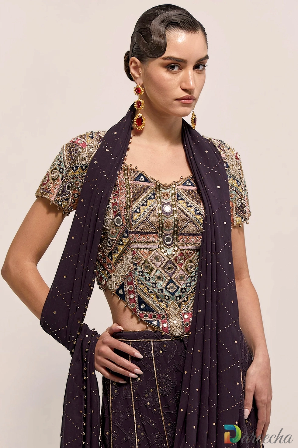 Close up portrait highlighting mirrorwork choli and draped mukaish pallu on dark purple georgette sharara