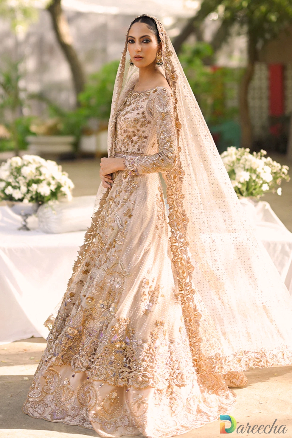 Full length side view of pale pink tulle peshwas lehenga showing flowing tissue skirt and draped dupatta