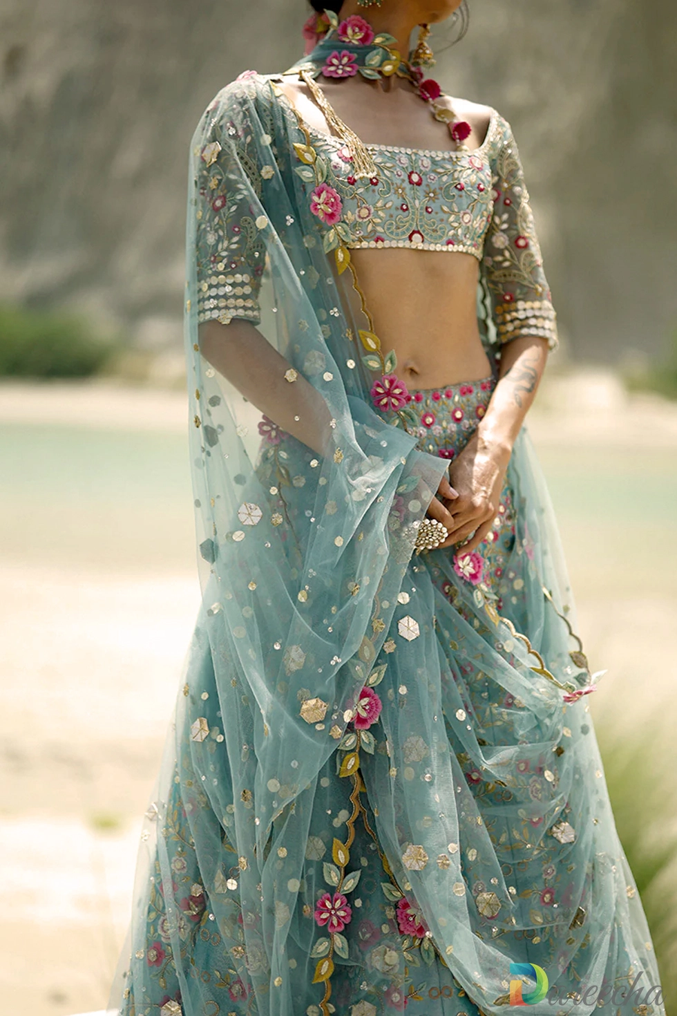 Outdoor portrait highlighting multi toned floral gota work on ice blue tissue lehenga
