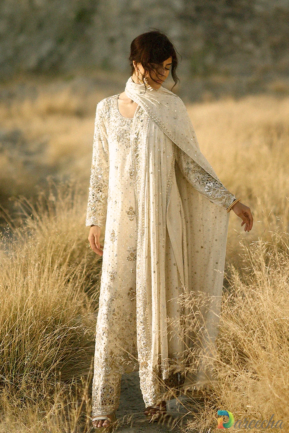 Close up view of model in the ivory hand embroidered long shirt detailing the round zardoze neckline and sleeve cuff embroidery