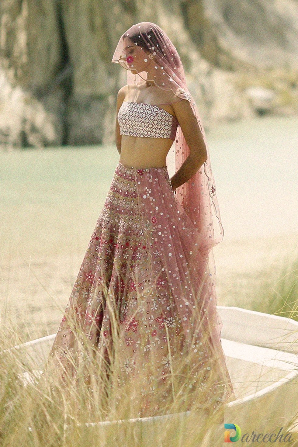 Front standing view of pink tulle angrakha lehenga showing crossover angrakha jacket and flared tissue lehenga