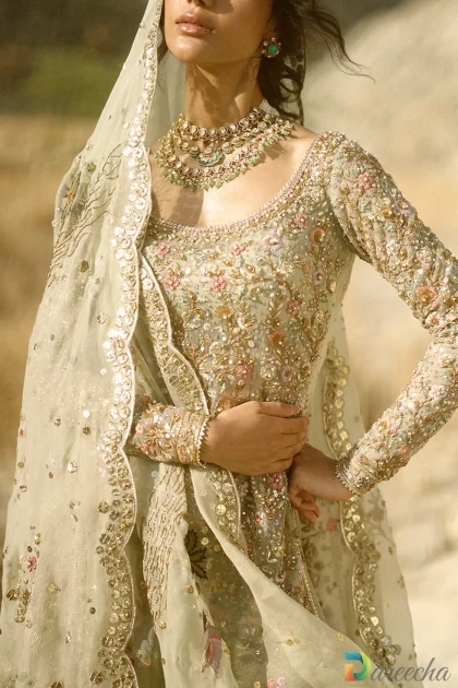 Close up profile of celadon tulle short shirt lehenga displaying chinoiserie crane and pagoda zardoze embroidery