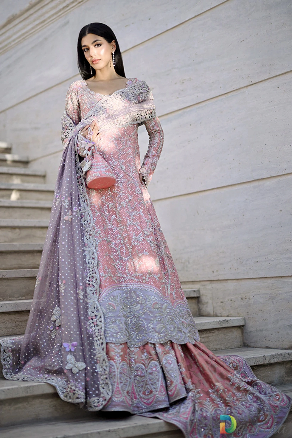 Front standing portrait of model in rose quartz peshwas lehenga showing lilac applique hem border