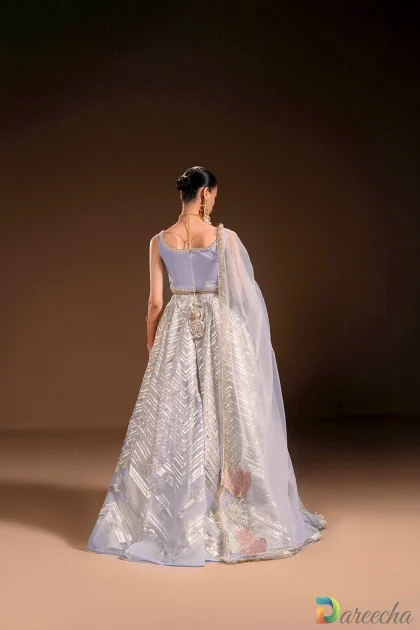 Back view showing strappy periwinkle silk choli with back ties and handcrafted potli tassel accents