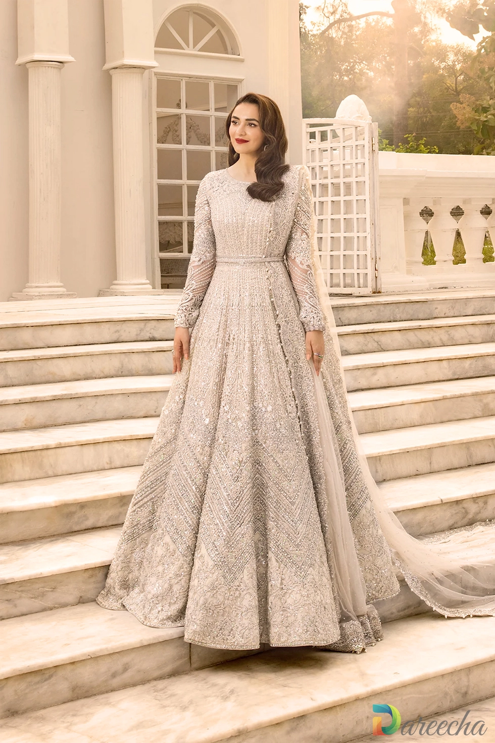 Full length standing portrait displaying net maxi gown