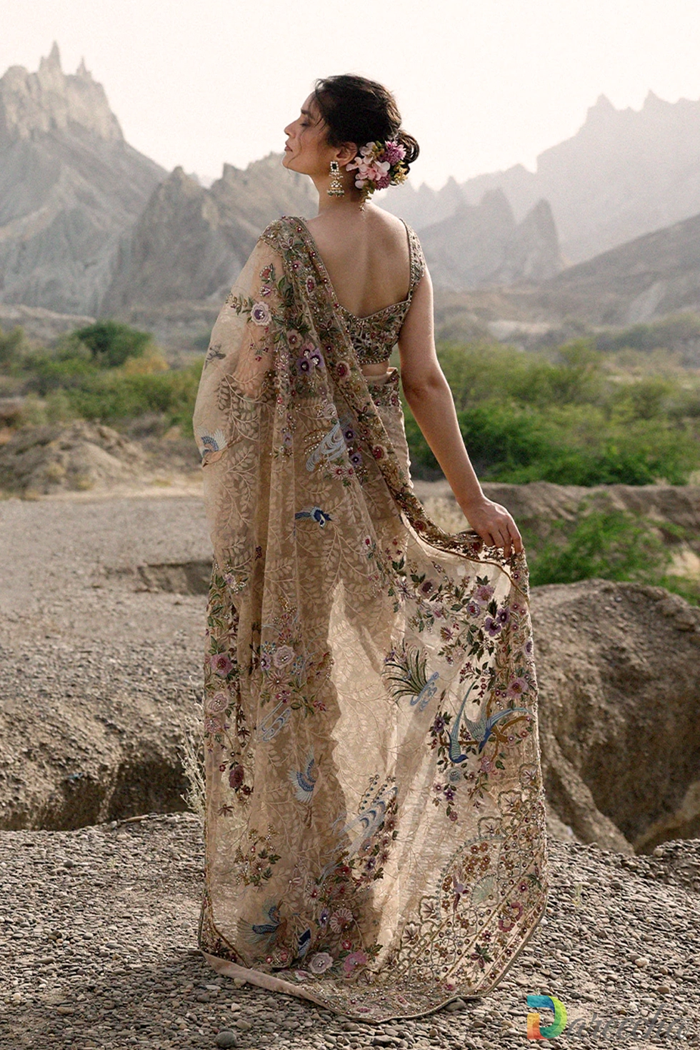 Back view of model wearing dusty gold tulle saree showing full spread pallu embroidered with cranes peacocks and paradise birds[cite: 28]