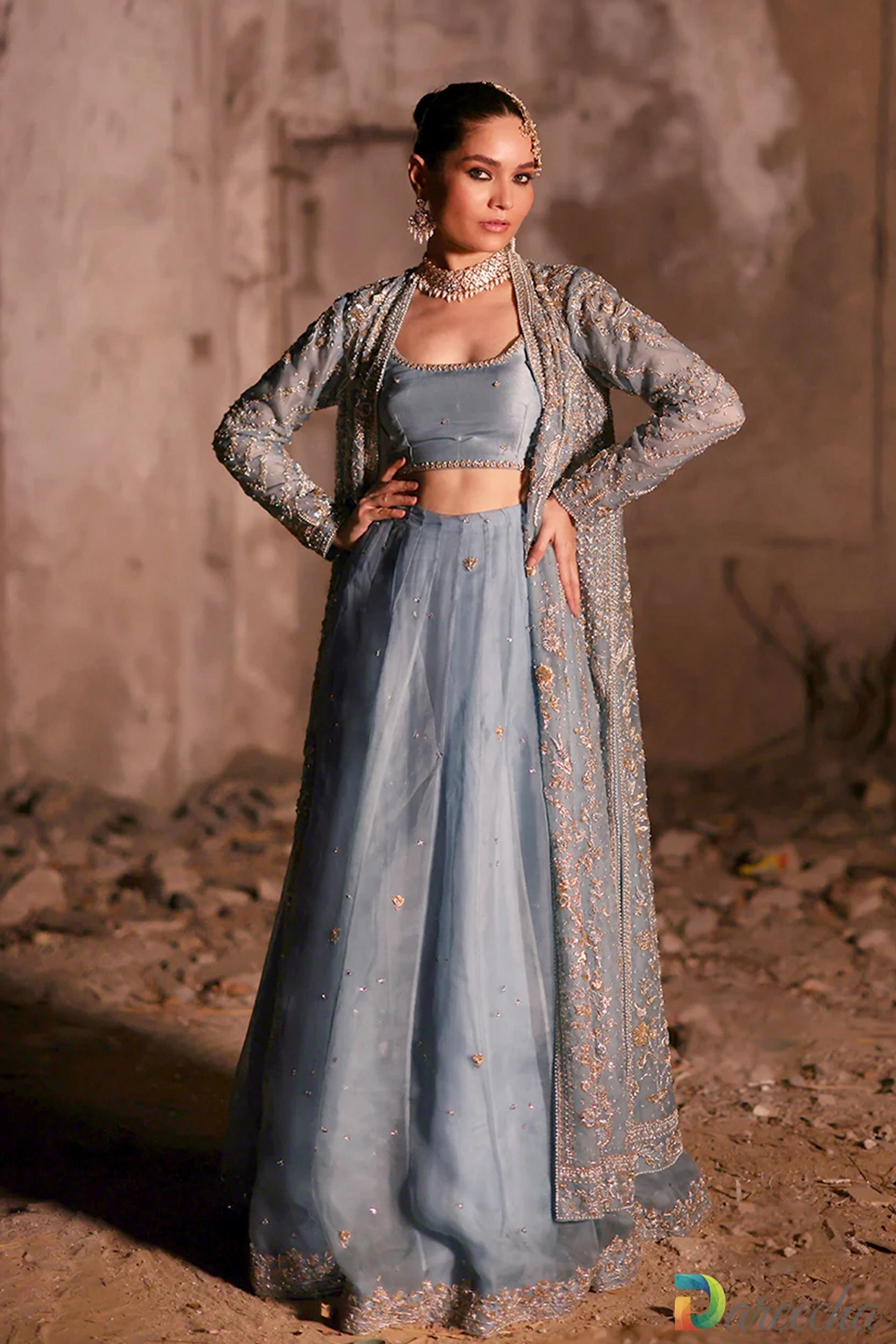 Front view of model wearing powder blue front open lehenga jacket with gold zardozi embroidery and organza dupatta