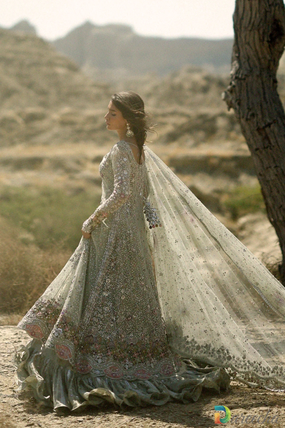 Side view of model in frosted mint peshwas lehenga displaying flared embroidered skirt panels and tissue brocade lehenga flounce[cite: 25]