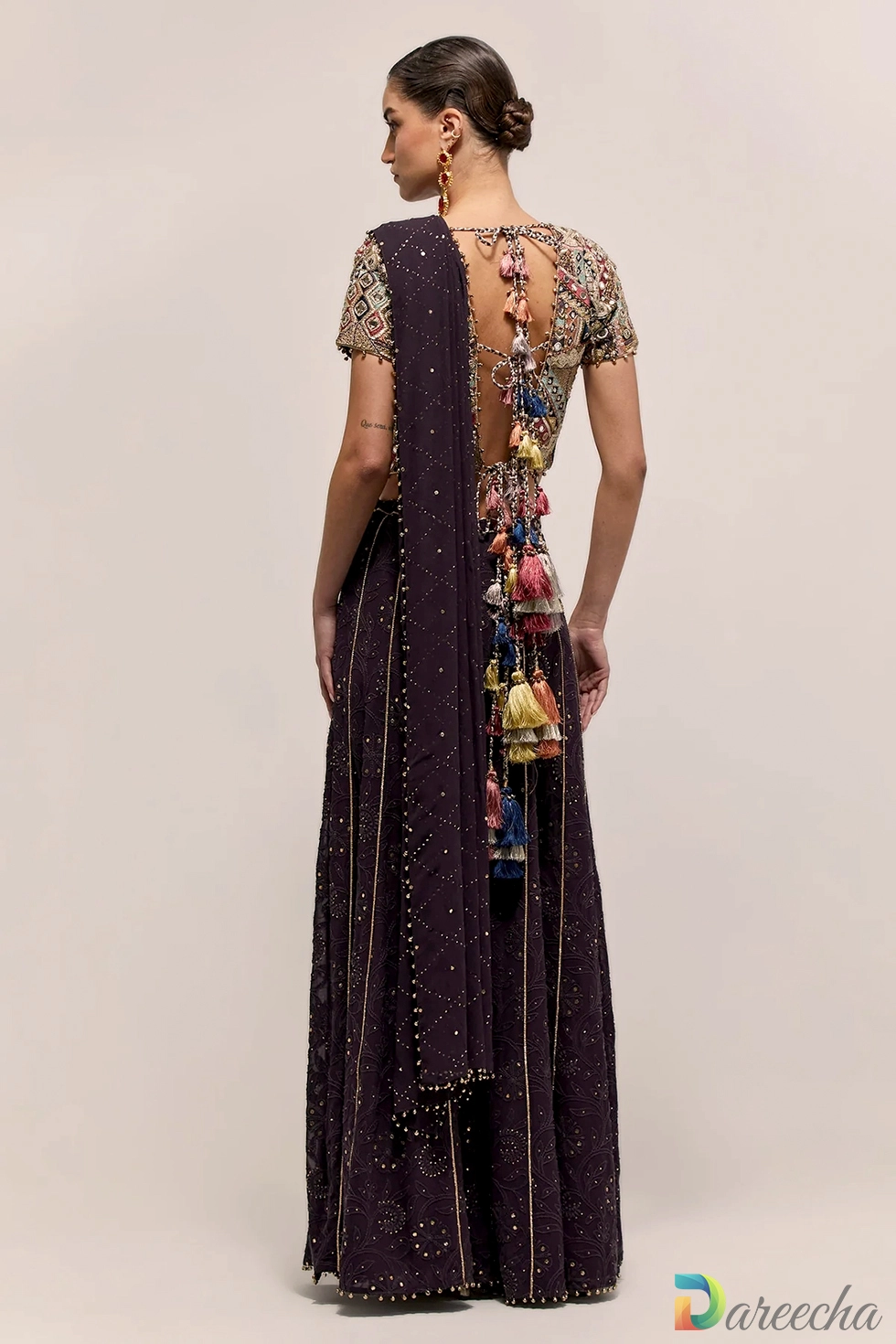 Full length back profile of dark purple georgette sharara showing cascading silk tassels and Lucknowi embroidered pants