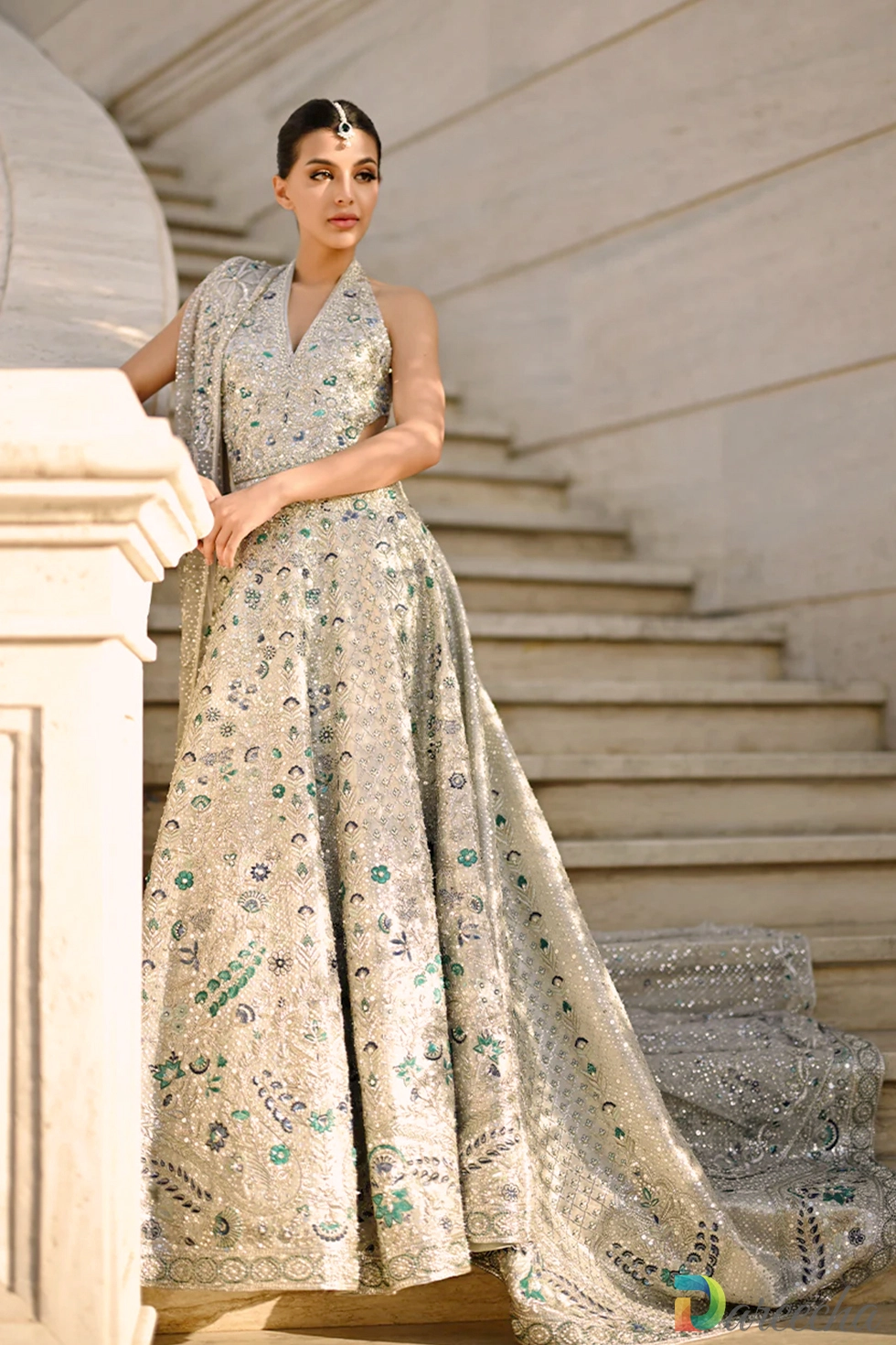 Front view of slim fit silver Backless Bridal Peshwas showing halter neckline and emerald resham floral details with tulle dupatta veiled over head.