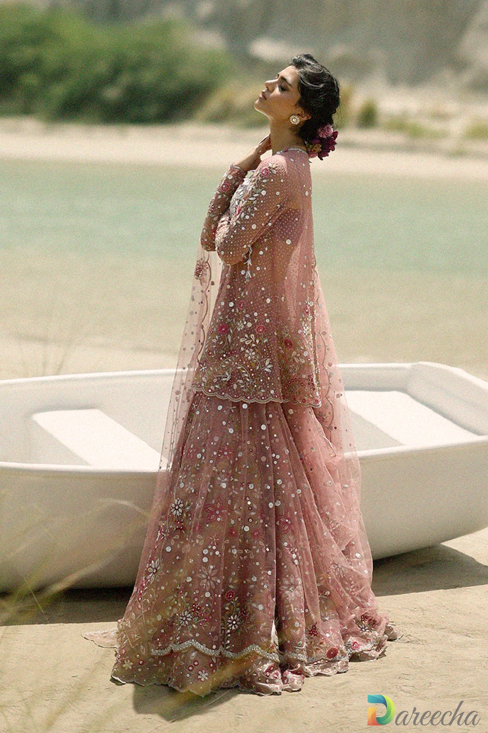 Full length side view of rose quartz pink tulle angrakha lehenga with scalloped jacket hem