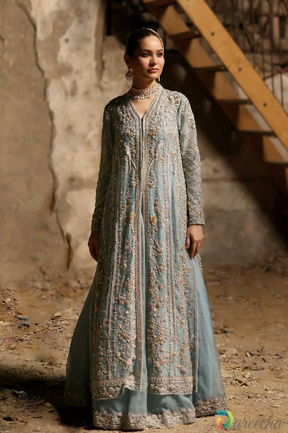 Standing pose highlighting front slit open jacket structure and organza lehenga on powder blue set