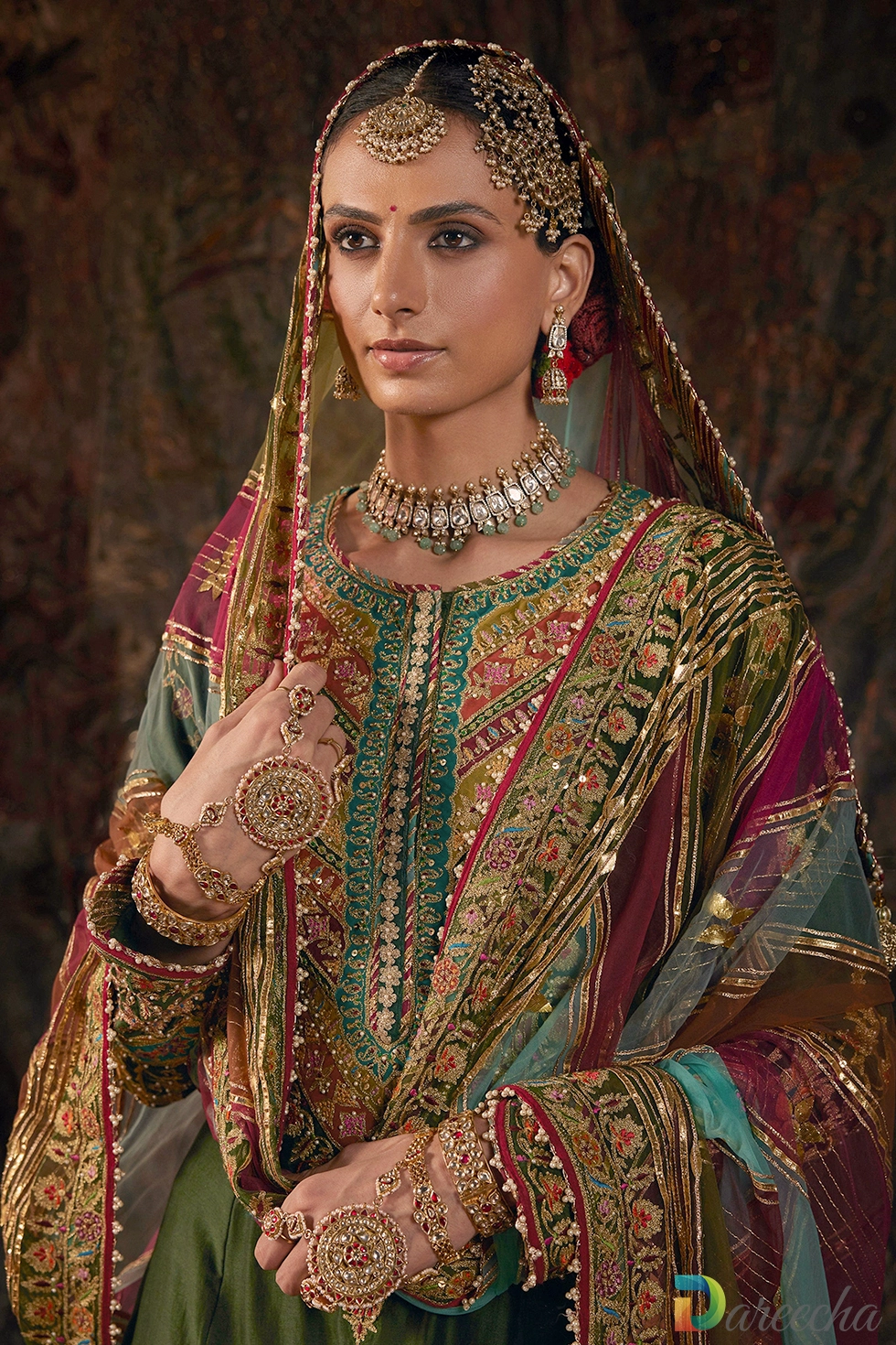 Close up portrait of model in forest green kurta featuring jeweled neckline, head dupatta, and draped Najeemabadi style dushala