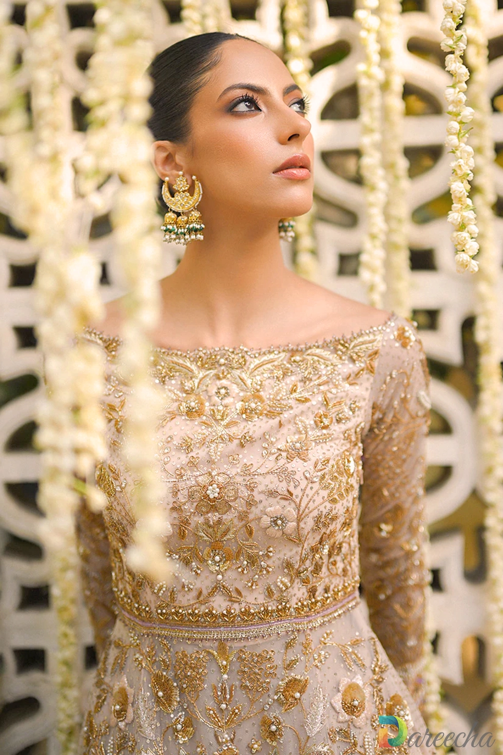 Standing portrait of pale pink tulle peshwas lehenga with draped scalloped dupatta draped over head