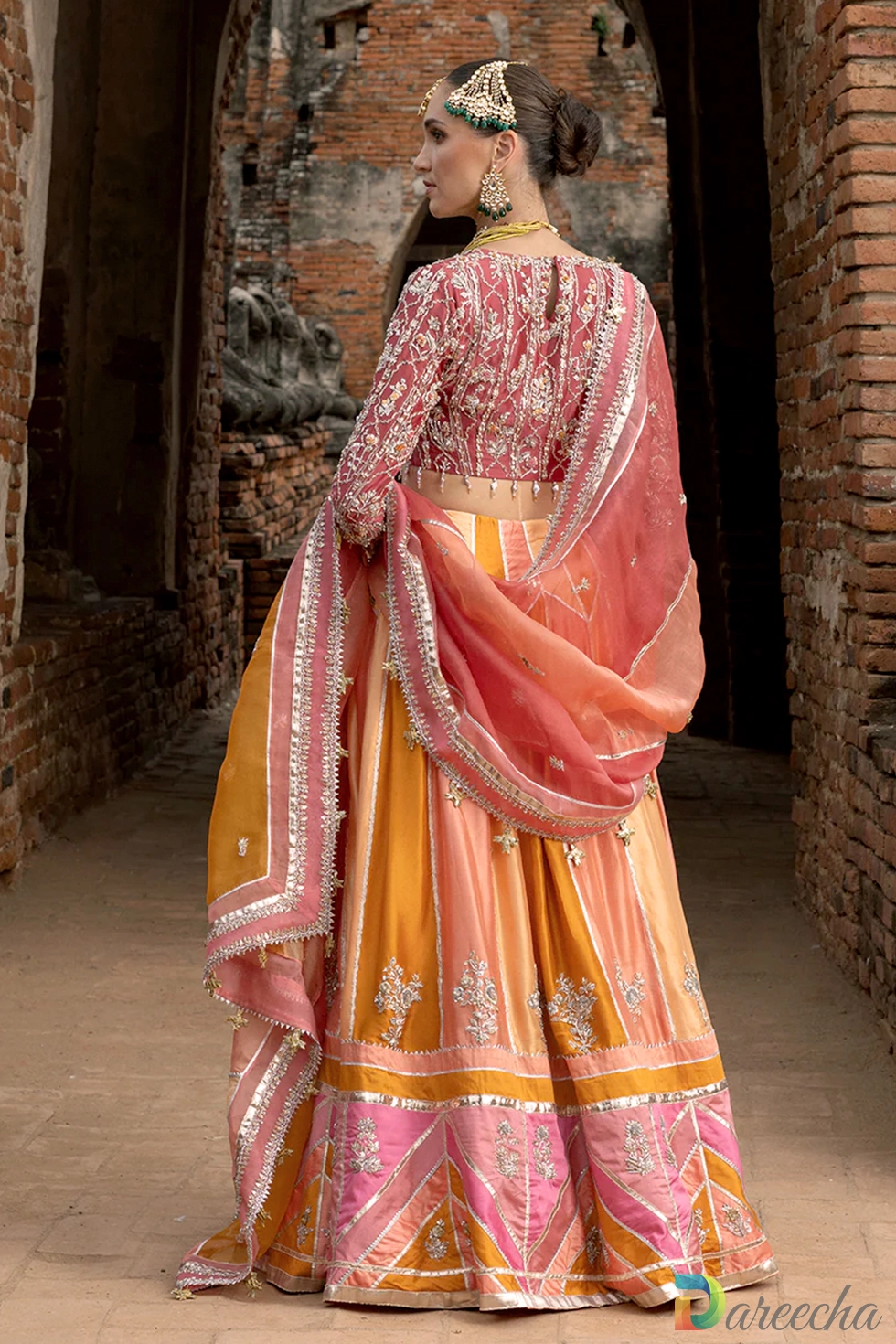 Back view showing keyhole blouse design and draped organza dupatta on multi color chatta pati lehenga