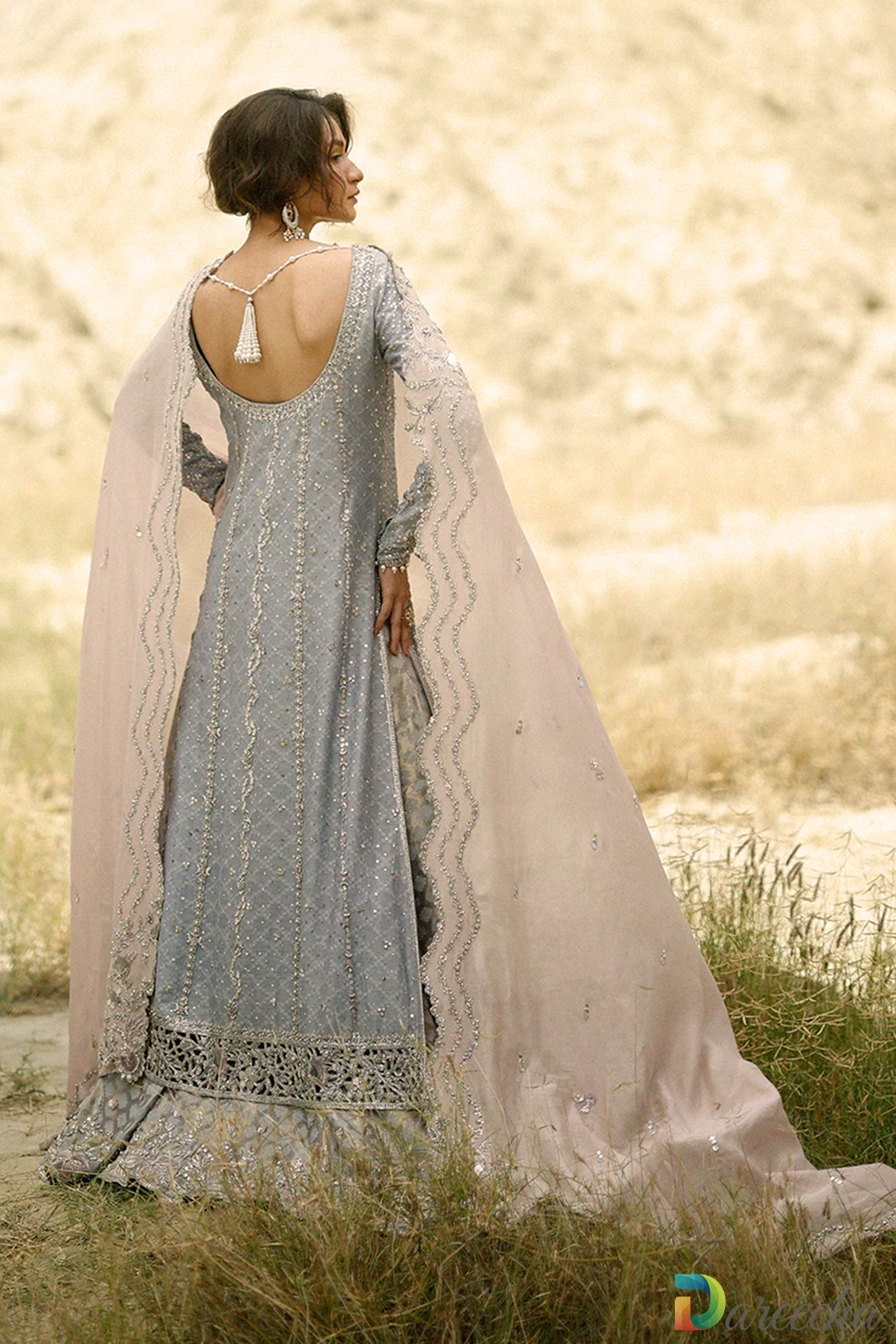 Back view showing deep round backline with pearl tassels and cutwork hem on steel blue long shirt with lehenga