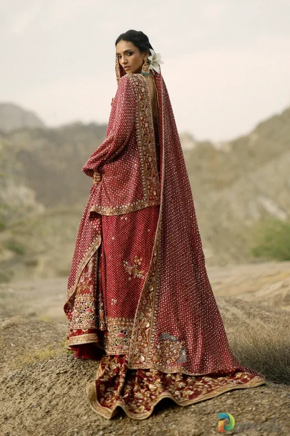 Rear side standing pose of model wearing crimson peshwas bridal lehenga displaying back detail and sweeping brocade skirt[cite: 38]
