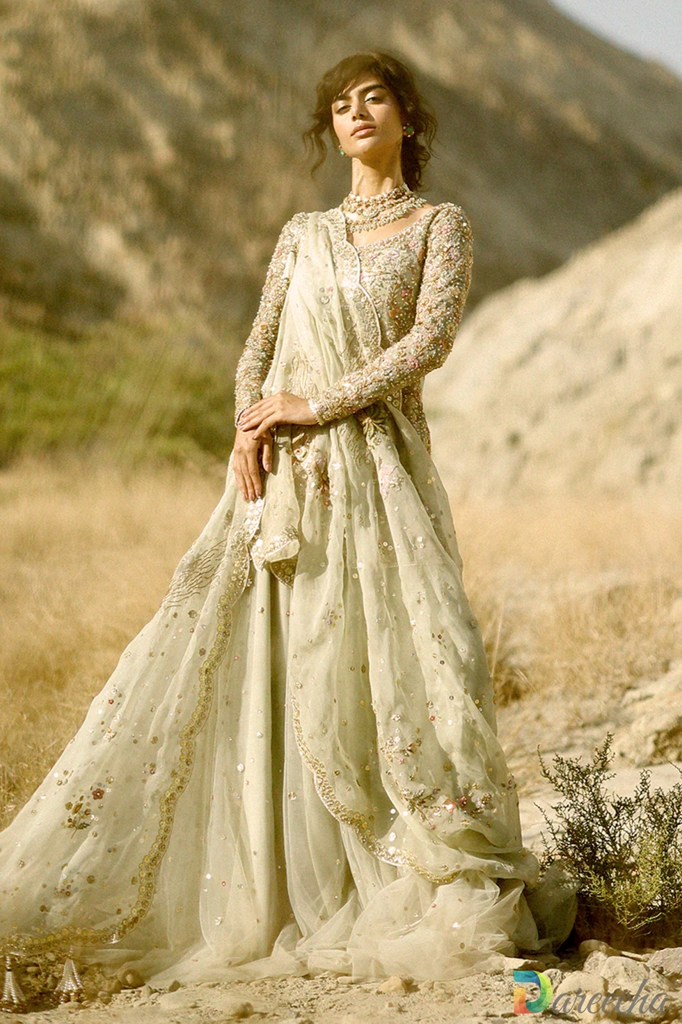 Front view of model in celadon tulle short shirt lehenga highlighting sequin dupatta and layered jamawar choli