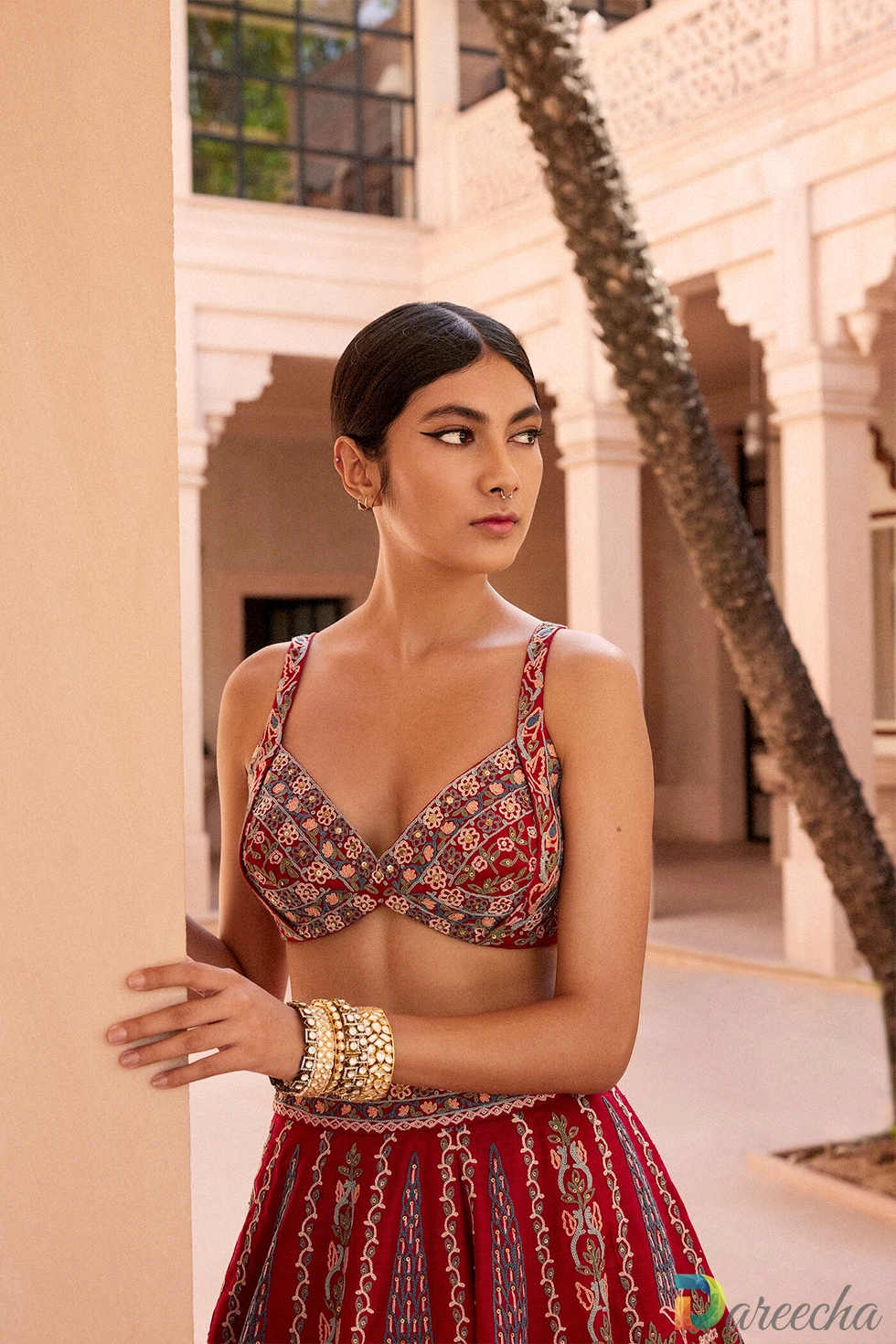 Close up portrait of model wearing embroidered sweetheart bustier top in vintage red matka silk