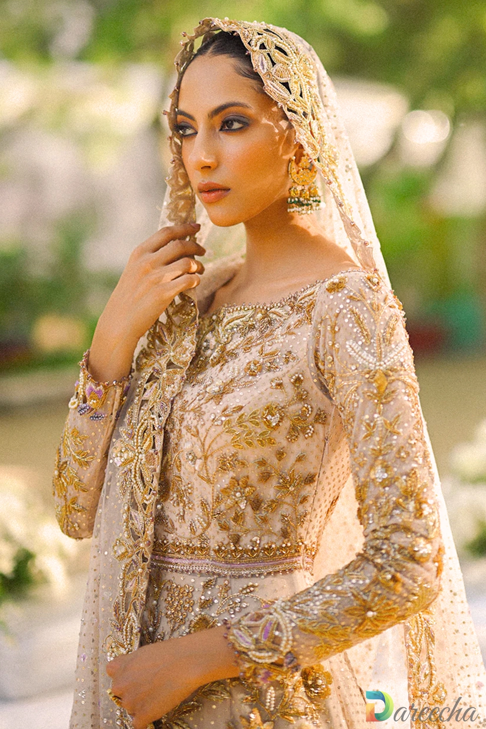 Close up profile of model in pale pink tulle peshwas lehenga showing scalloped dupatta border and off shoulder zardoze embroidery