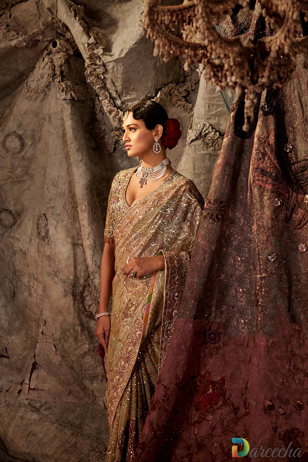 Pale pistachio green tulle saree with gold sequin cloudscape detailing and pearl necklace