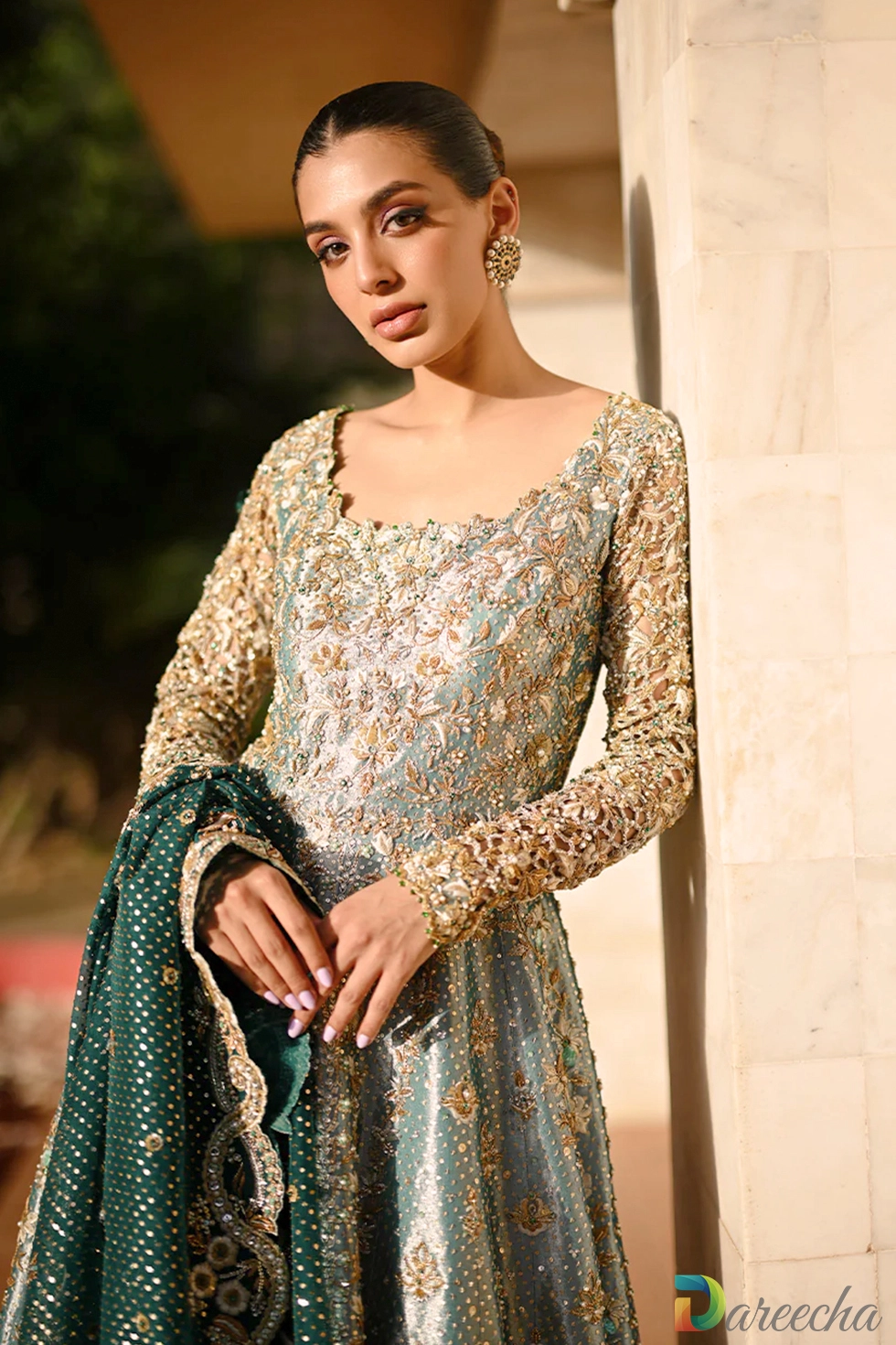 Close up pose highlighting round neckline embroidery and cutwork sleeves on mint green tissue peshwas