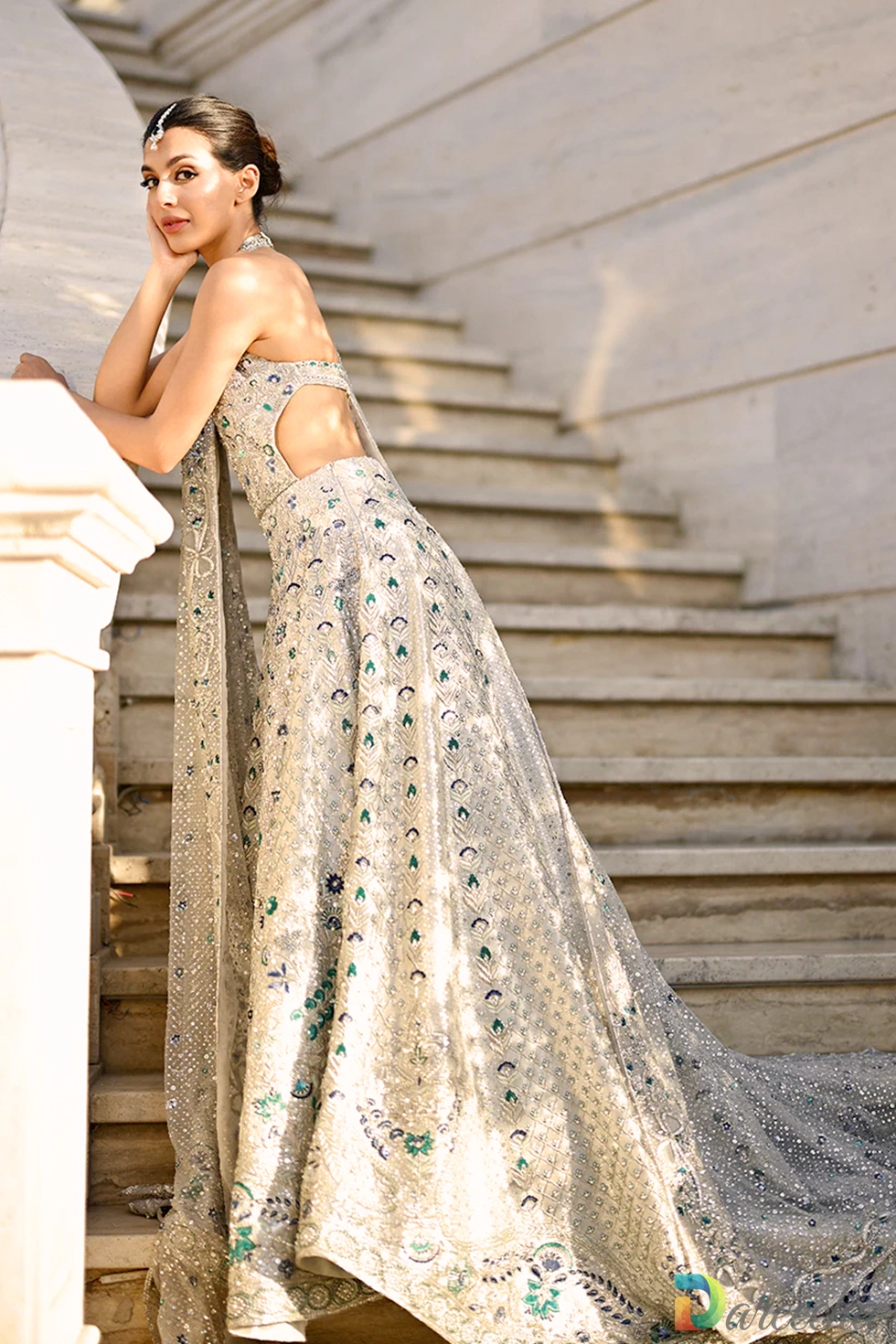 Close-up profile of open back halter design with intricate hand-embroidered zardoze border details on platinum tissue.
