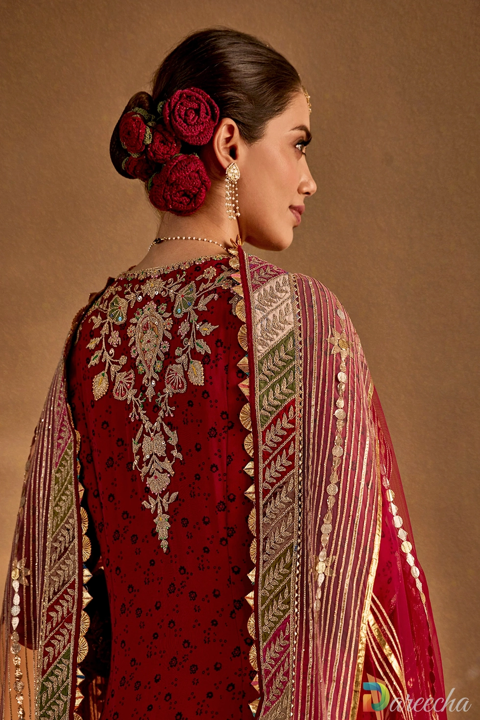 Back view of a deep maroon printed silk kurta set showcasing hand-embroidered back motifs and draped organza dupatta.