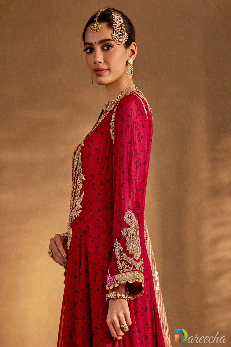 Close-up of rich marodi embroidery, pearls, zardozi work, and chevron borders on a maroon silk kurta hem.