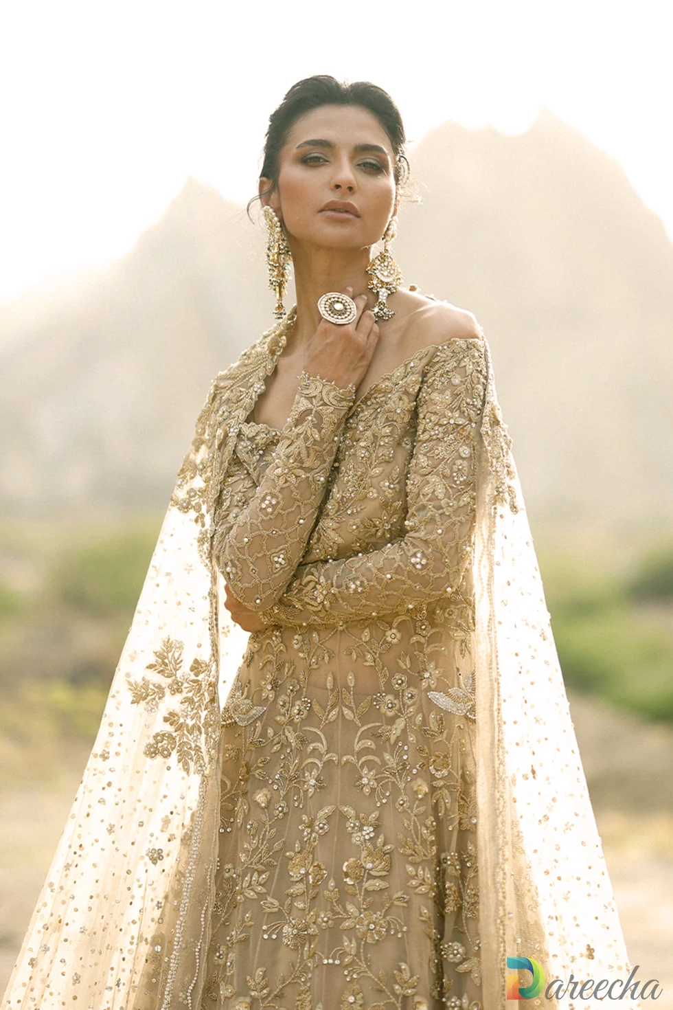 Muted hand-embroidered tulle gold bridal peshwas with tissue lehenga and veiling dupatta.